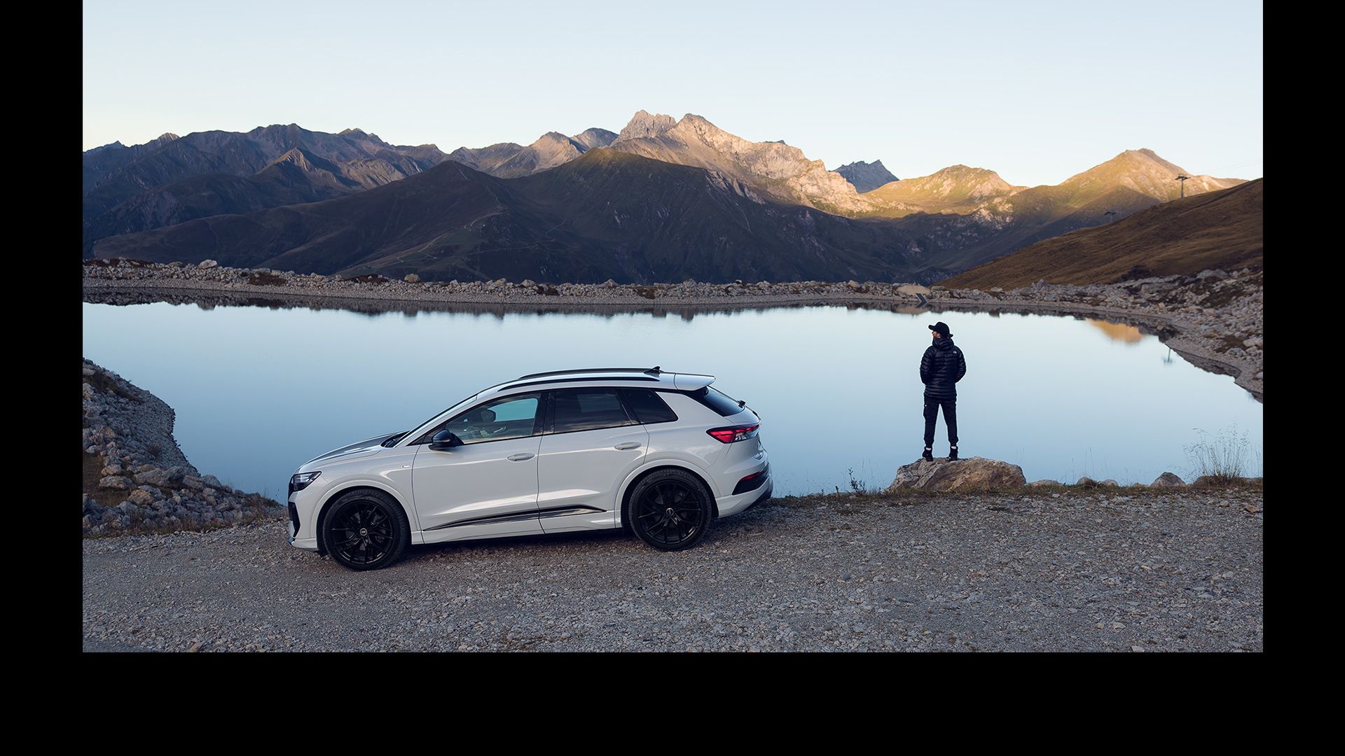 Een witte Audi Q4 e-tron bij een bergmeer